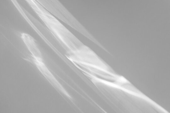 Blurred water texture overlay effect for photo and mockups. Organic drop diagonal shadow and light caustic effect on a white wall. Shadows for natural light effects