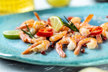Grilled shrimps or prawns served with lime, rosemary, chili. Seafood. Food recipe background. Close up