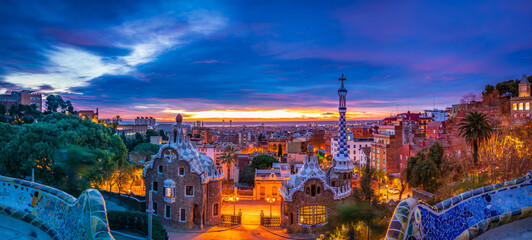 Sunrise in Barcelona seen from Park Guell. Park was built from 1900 to 1914 and was officially opened as a public park in 1926. In 1984, UNESCO declared the park a World Heritage Site - obrazy, fototapety, plakaty