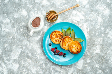 top view delicious muffins with berries on light background taste photo sweet pancake dough fruit