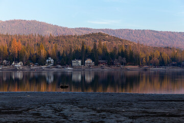 A serene lake just outside Yosemite National Park at sunset with a mountain range in the background.
