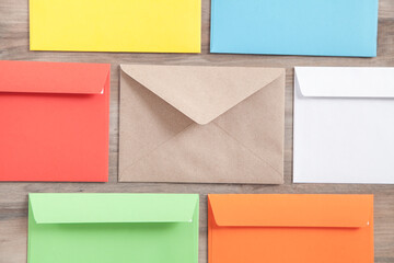 Colorful mail envelopes on the wooden background.