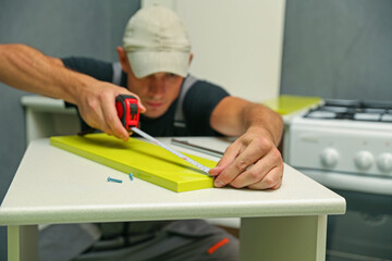 worker measuring furniture part close up