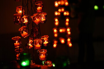 Candlelight illuminating many orange glass bottles
