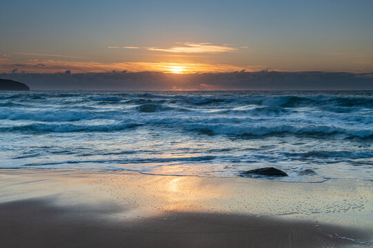 Sunrise seascape with light cloud and waves