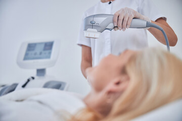Woman hand with modern specializing ultrasound machine above patient