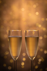 Champagne glasses over holiday bokeh blinking background, rotating on turntable, glasses with sparkling wine, celebration, party. High quality 4k footage