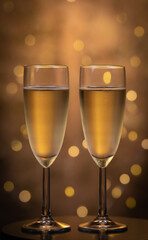 Champagne glasses over holiday bokeh blinking background, rotating on turntable, glasses with sparkling wine, celebration, party. High quality 4k footage