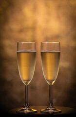 Champagne glasses over holiday bokeh blinking background, rotating on turntable, glasses with sparkling wine, celebration, party. High quality 4k footage