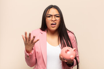 young latin woman looking angry, annoyed and frustrated screaming wtf or what’s wrong with you