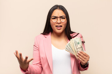 young latin woman looking angry, annoyed and frustrated screaming wtf or what’s wrong with you