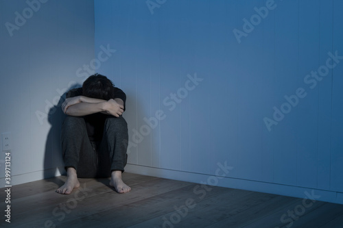 暗い部屋で床に座り込んだ男性 Wall Mural Wallpaper Murals Kai