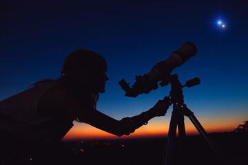 Woman looking at night sky with amateur astronomical telescope. © astrosystem