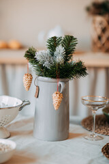 Christmas decorations. Fir branches with snow inside the vase on the christmas table. Decoration of festive table for christmas eve. Festive dish for new year eve.