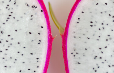 Closeup macro photo two halfs of Dragon Fruit with many black seed and pink cover