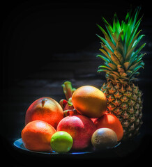 
Various fruits like pineapple, papaya, orange, passion fruit, and others are on the table.