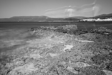 Long exposure black and white image of Urla, Altinkoy bay. A boy looked like a ghost.