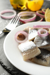 Black tray with plate of fresh herring fish slices