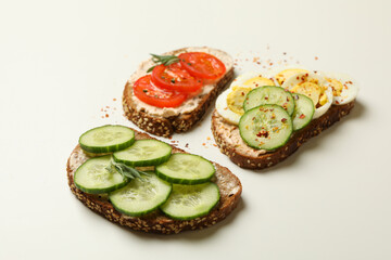 Tasty toasts with different topping on white background