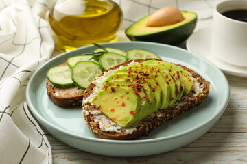 Concept of breakfast with toasts with avocado and cucumber on wooden table