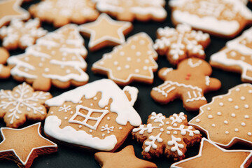 Winter holiday pattern-a set of gingerbread, the layout of the pattern on a dark background. cookies in the form of a house, a christmas tree, a person, a star decorated with icing.