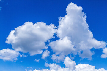Naklejka na ściany i meble White clouds on a blue sky. Blue sky with heavy clouds. Clouds floating on the sky.
