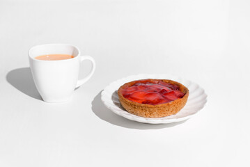 Morning breakfast with berry cheesecake. Cup of tea and fruit cheesecake on a white table.