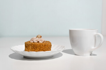 Cup of tea and cake decorated with cream and nuts. Morning breakfast with dessert in the kitchen.