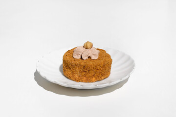 Cake decorated with cream and nuts, white table background. Morning breakfast with dessert in the kitchen.