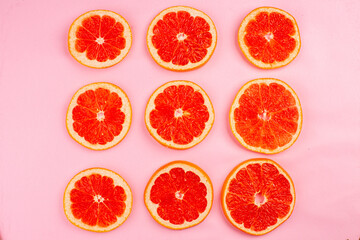 top view tasty grapefruits sliced juicy fruits lined on a pink background juice fresh fruit color citrus diet
