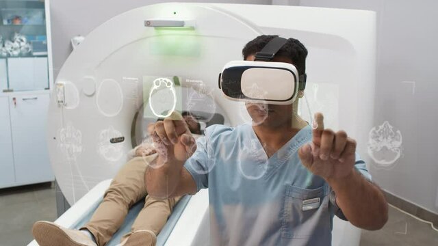 Medium cgi graphics shot of doctor in vr headset examining patient touching holographic objects with man lying at futuristic white computer tomograph in background