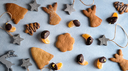 Gingerbread cookies with chocolate-covered tangerine slices and Christmas decor.