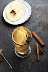 Hot winter Christmas drink in a glass mug: herbal tea with cinnamon, Apple and spices.
