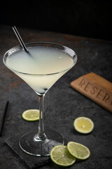 Classic Daiquiri cocktail of rum and lime juice on a dark stone background