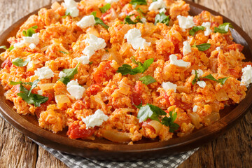 Strapatsada is a popular dish in many regions of Greece consisting of eggs, onions, tomatoes closeup in the plate on the table. horizontal