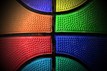 Extreme closeup of an old multi colored basketball, orange, red, yellow, blue, green, purple and black.