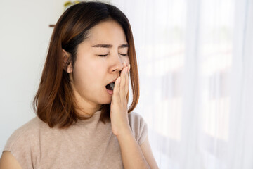 Asian woman yawning wake up not feeling fresh , no energy in the morning