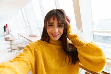 Charming happy nice girl taking selfie photo and smiling indoors