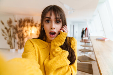 Charming shocked nice girl taking selfie photo and expressing surprise