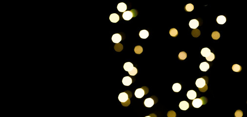 background with beautiful shiny christmas lights, abstract lights defocused with black backdrop and space for text, no person, 
