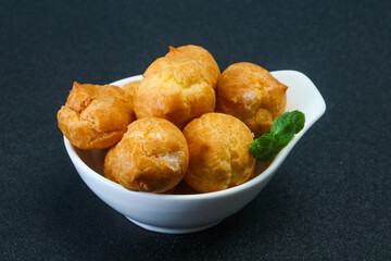 Sweet tasty profiteroles heap in the bowl