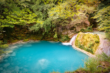 Fototapeta na wymiar small river of turquoise water with a waterfall that ends in a pond
