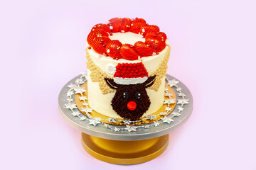 New Year's festive Christmas cake on a stand on a pink background. Christmas sweets decorated with New Year's decor and berries.