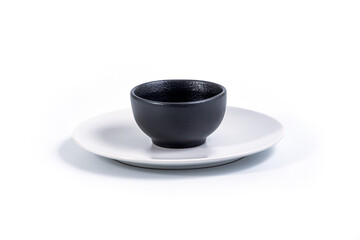 Black Bowl in White Plate isolated on white background, side view.