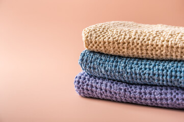 Multicolored linen and cotton bath and spa towels on pink background, body care concept, close-up, copy space