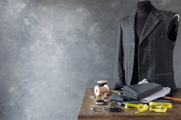 suit jacket on male tailor mannequin and sewing tools
