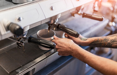 Crop employee using coffee machine in cafe
