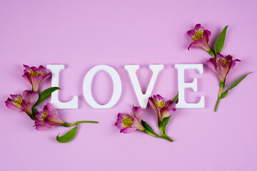 St.Valentine's card. The word love on a pink background with alstroemerias