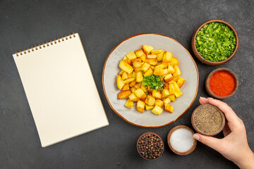 top view tasty fried potatoes inside plate with seasonings on dark background color oil kitchen dinner food
