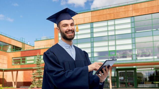 education, graduation and people concept - happy smiling male graduate student in mortar board and bachelor gown with tablet pc computer over school background - Powered by Adobe